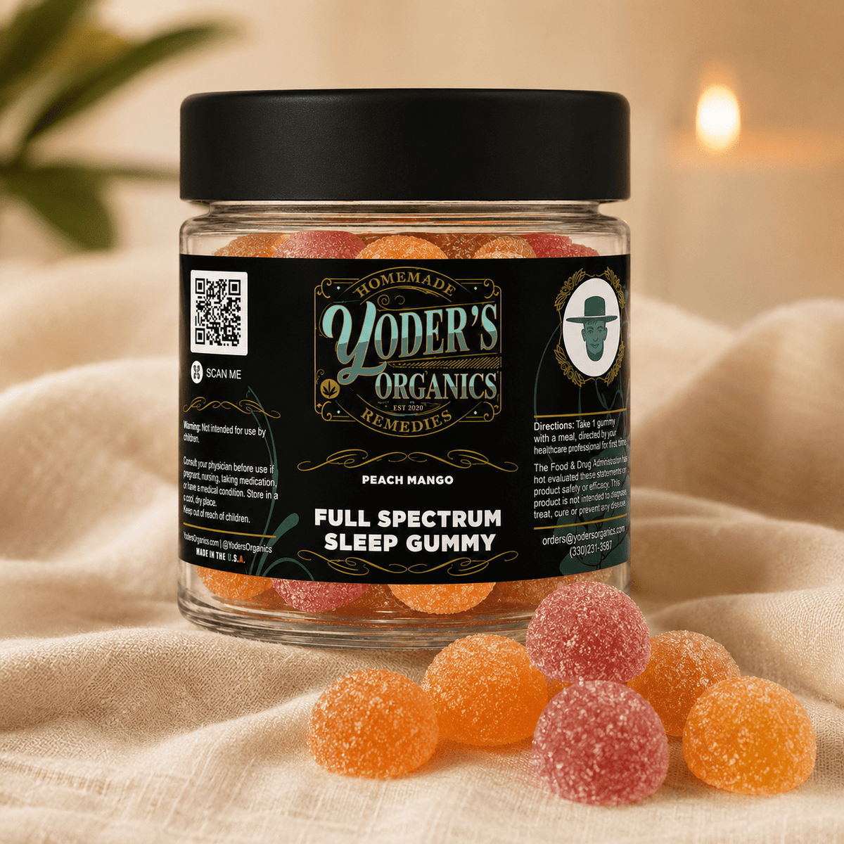 Jar of Peach Mango CBN sleep gummies with loose gummies by candlelight