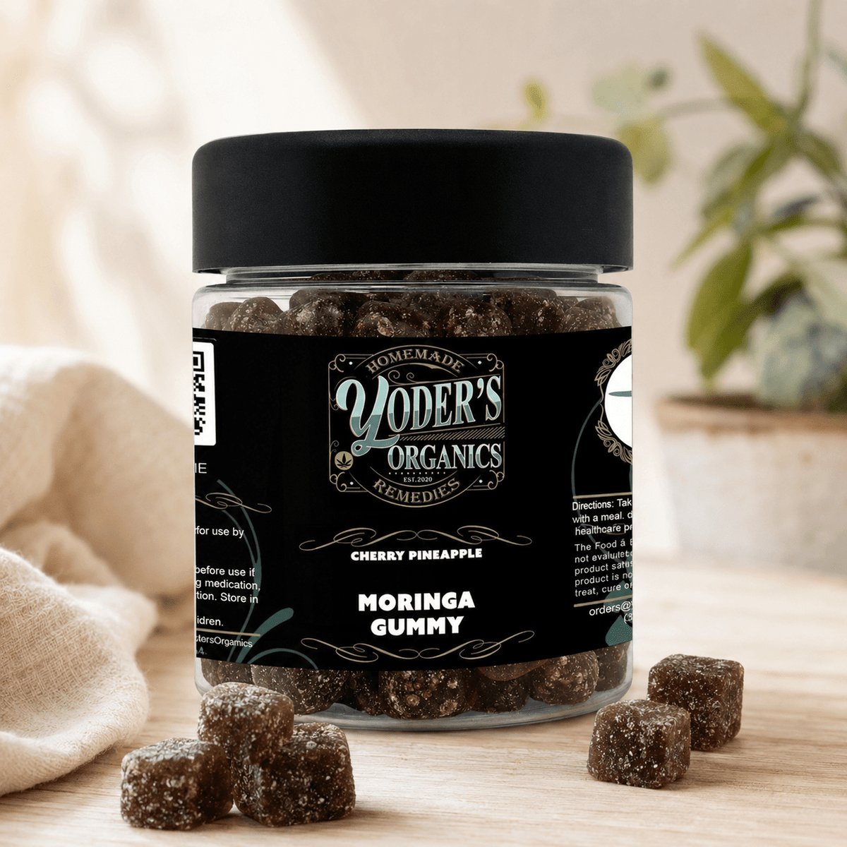 Moringa gummies jar with a few gummies on a linen cloth